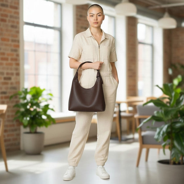 Modelo con bolso Xava BE XAVAGE marrón de diseño minimalista y silueta amplia en un entorno de oficina moderno