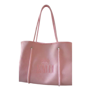 Bolso tote Xava rosa de material sintético con textura perforada, iniciales bordadas y corona en el centro